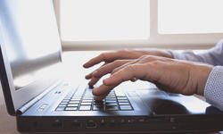 Man hands typing on keyboard laptop